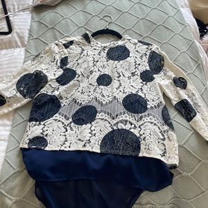Lace blouse with blue polka dot detail.